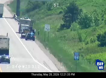 Emergency vehicles and personnel on the roadside with traffic control.
