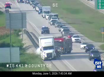 Police car and emergency personnel responding to traffic incident on highway.