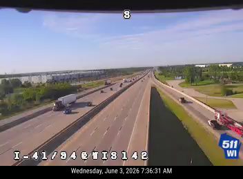 Emergency responders and equipment are visible on the right shoulder of the highway.