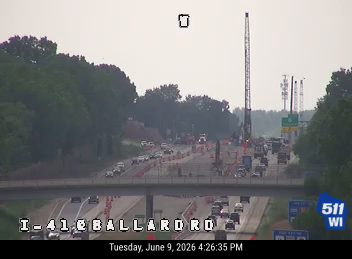 Construction zone with crane and emergency vehicles on highway.