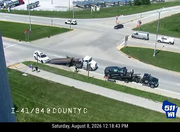 Two tow trucks with vehicles on them on the right shoulder