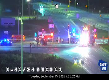 Multiple emergency vehicles and people on the roadway