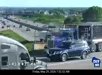 Two large trucks and a car appear to be involved in a collision on-road collision.