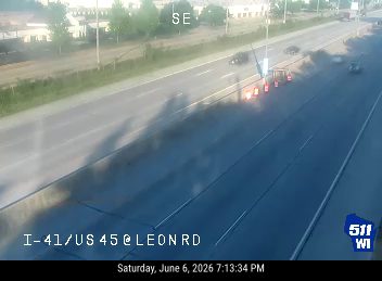 Vehicle fire on the highway with smoke and cones present.