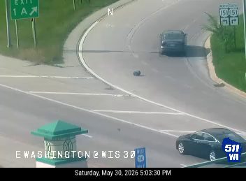 A dark object, possibly debris, is in the roadway on a curve.