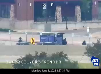 Police officers are present at a roadside incident near a bus stop.