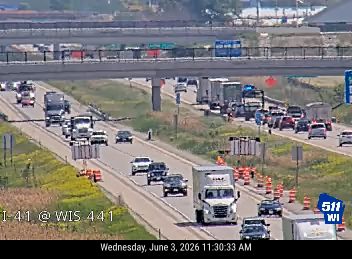 Emergency responders and traffic cones on the highway indicate an incident.