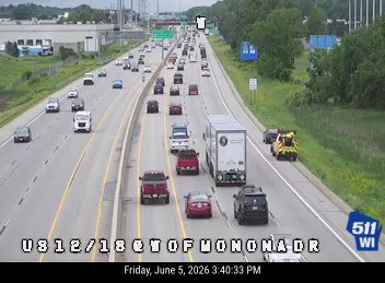 Tow truck and other vehicles stopped on the shoulder of the highway.