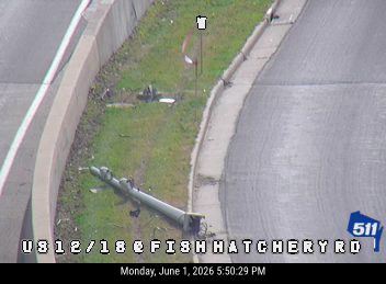 A downed pole and debris are visible on the side of the road.
