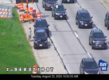 Damaged vehicle with police officer present on the right shoulder
