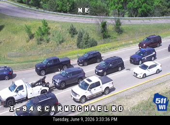 Tow truck and white pickup truck stopped on the shoulder, possibly assisting another vehicle.