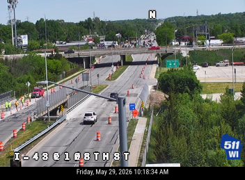 Multiple responders and vehicles on the side of the road with cones and barriers.