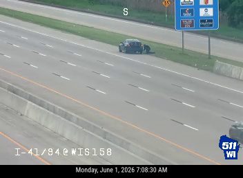 Police and tow truck on scene with flashing lights on highway.