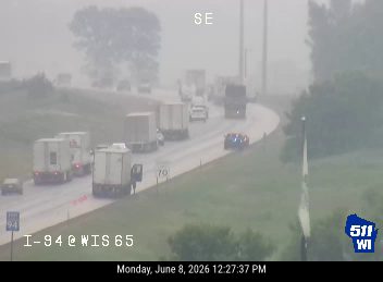 Police car and possibly other responders on the side of the road with traffic backing up.