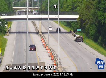 A truck and cones are on the right shoulder, possibly indicating a responder or work crew.