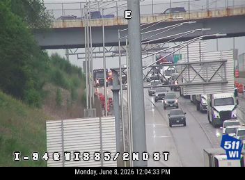 Emergency responders with flashing lights on the highway shoulder.
