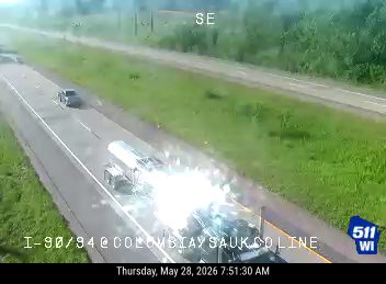 A tanker truck is on fire on the highway, causing a bright explosion.