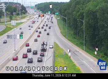 Emergency vehicle with lights on, blocking traffic on highway.