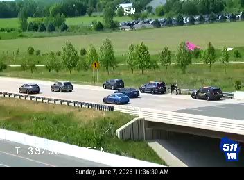 Police cars and personnel on the roadside, indicating an incident response.
