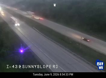 Emergency vehicle with flashing lights on the shoulder of I-43 at Sunnyslope Rd.