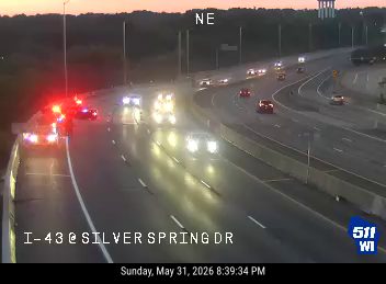 Emergency vehicles with flashing lights on the highway, likely responding to an incident.