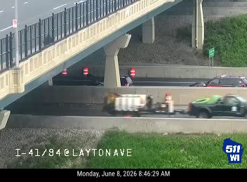 Emergency vehicle and cones on highway, indicating a possible incident response.