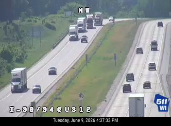 Police and possibly other responders on the highway shoulder with vehicles.