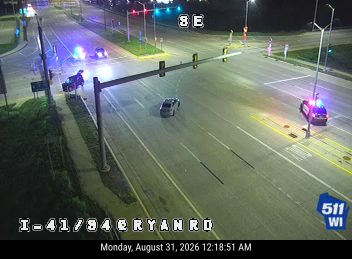 Two police cars with lights on at intersection