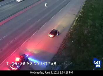 Police car with flashing lights on the shoulder of the highway.