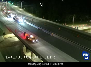 Two police cars with red and blue lights on the shoulder