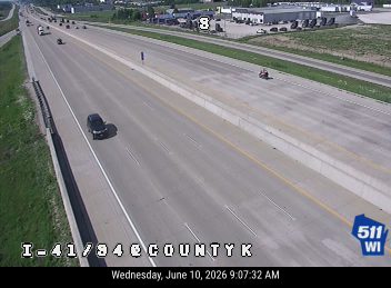 Emergency vehicle and personnel on the right shoulder of the highway.
