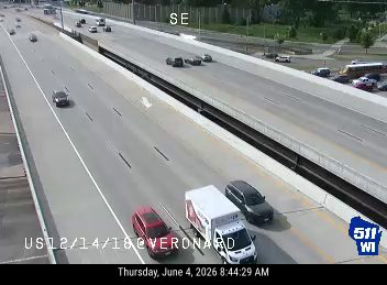 Emergency vehicles and a tow truck are stopped on the shoulder, blocking a lane.