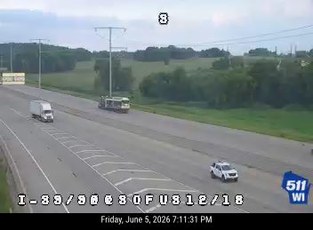 Police vehicle stopped on the shoulder of the highway.