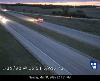 Emergency vehicle on the shoulder of the highway with lights on.