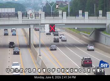 Emergency vehicle with flashing lights on highway, traffic stopped.