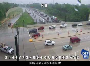 Emergency vehicles and cones on the roadway indicate an incident response.