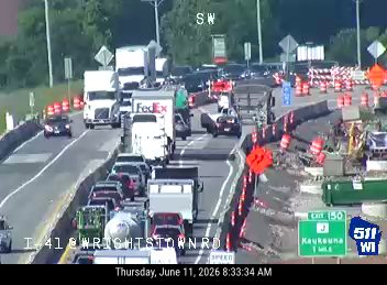Multiple vehicles involved in a traffic jam, possibly a crash, with construction barriers.
