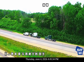 Two trucks and a white vehicle stopped on the highway, possibly a responder scene.