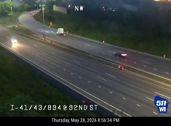 Emergency vehicle and personnel on the side of the highway with cones.