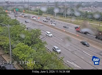 A truck is on fire on the highway, emitting smoke.