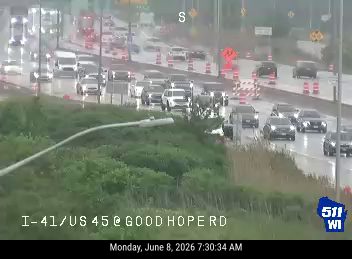 Emergency vehicles and cones on the highway, indicating an incident response.