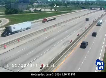 Emergency vehicle and cones on the right shoulder of the highway.