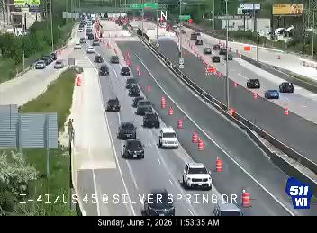 Emergency responders and cones on the highway, indicating an incident.