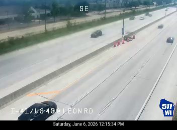 Emergency vehicle and cones on the highway shoulder, indicating a responder incident.