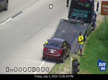 Tow truck loading a maroon sedan on the right shoulder