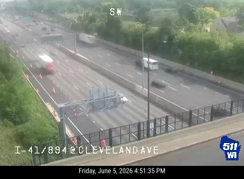 Overturned vehicle blocking multiple lanes of highway traffic.