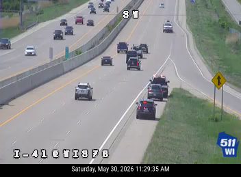 Police and emergency vehicle on the shoulder with personnel present.