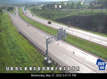 Emergency responders and cones are present on the right shoulder of the highway.