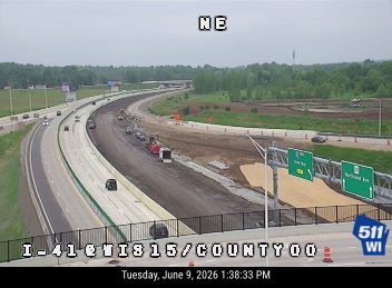 Construction zone with multiple vehicles and workers present on the roadway.