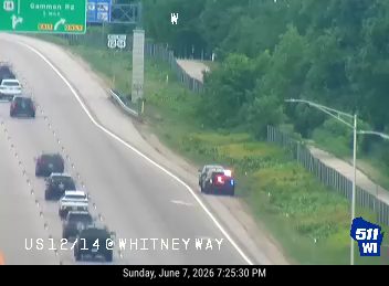 Police car with lights on pulled over on the shoulder of the highway.